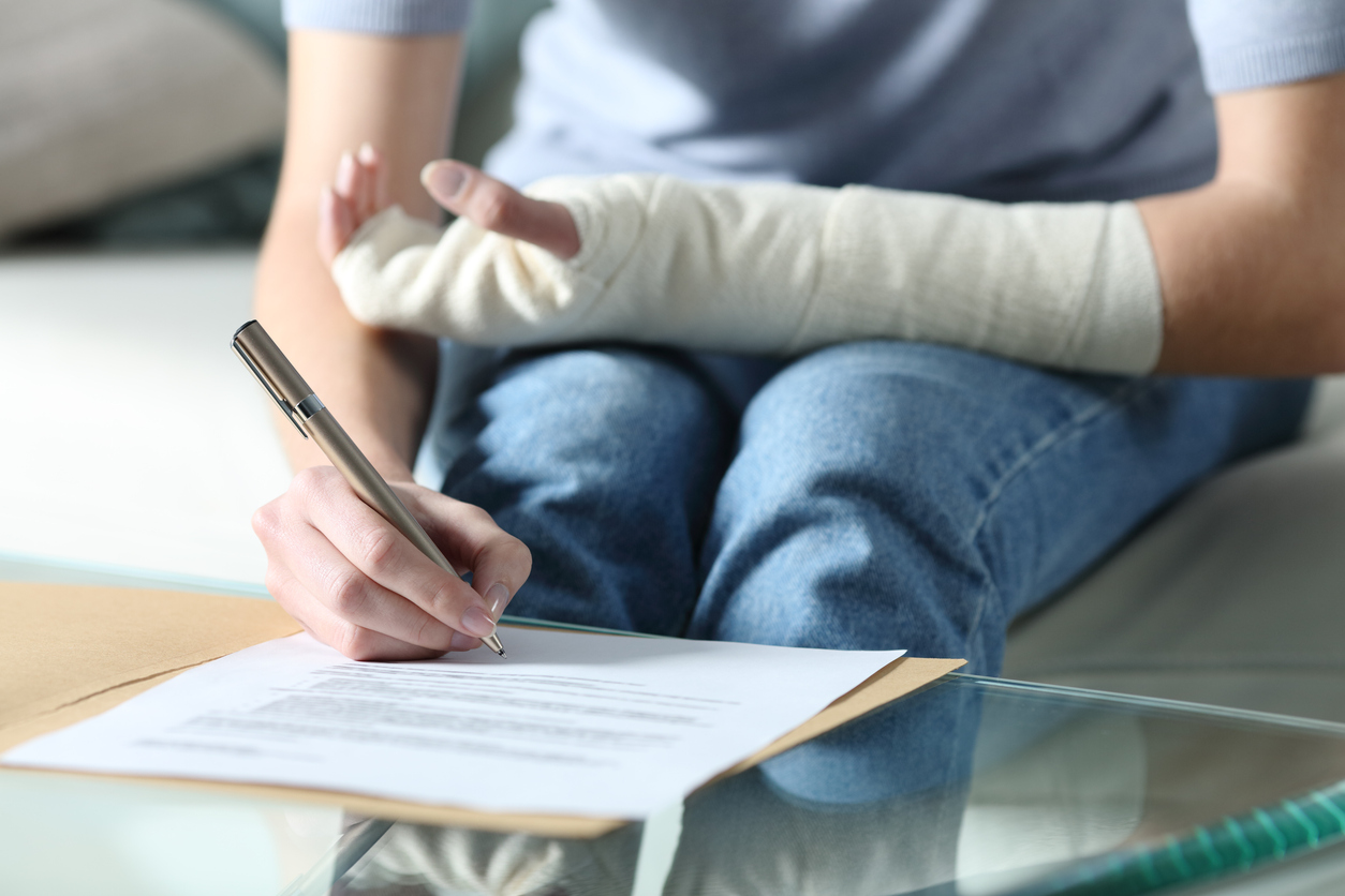 An woman with an injured arm writing a letter